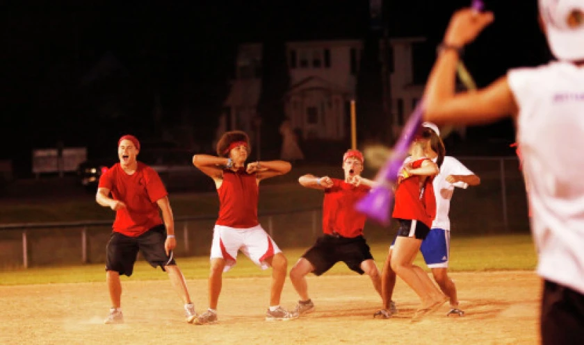 A team in red shirts and headbands mid-choreography during the third-place dance-off
